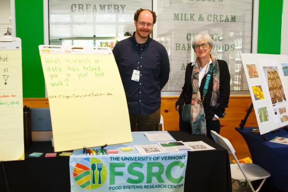 Andrew May and Polly Ericksen of the UVM Food Systems Research Center at their display table at the 2023 Food Institute New England Summit (FINE)