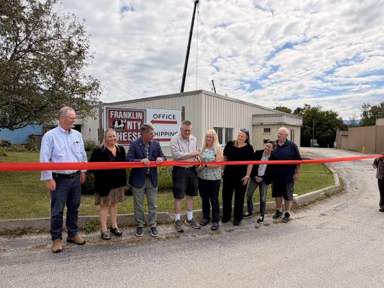 Franklin County Cheese owners John and Kathy Ovitt (center) join community partners and state officials for a ribbon-cutting ceremony Sept. 1 celebrating the reopening of the Enosburg Falls facility. 